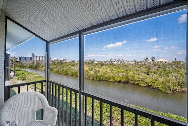 sunroom / solarium featuring a water view