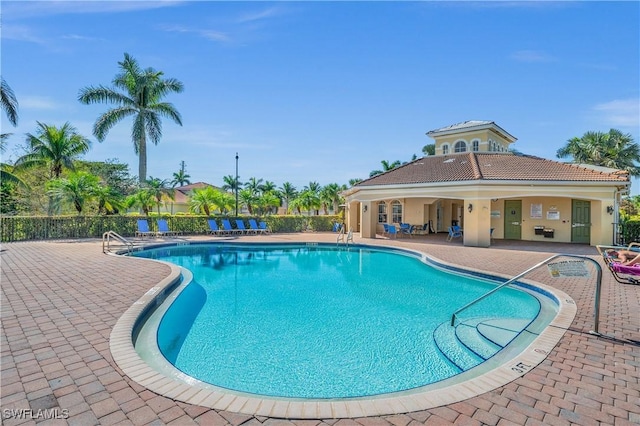 community pool featuring fence and a patio