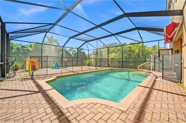 view of pool with a playground, a lanai, and a patio area