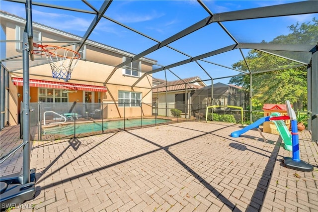 pool with a patio area and glass enclosure