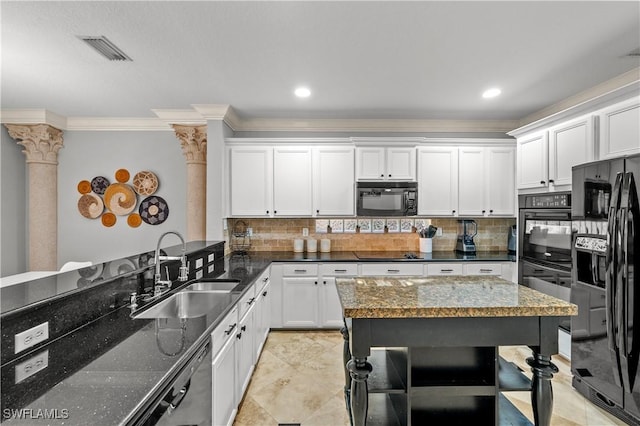 kitchen featuring sink, white cabinetry, decorative columns, black appliances, and dark stone counters