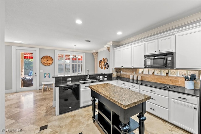 kitchen with pendant lighting, white cabinets, sink, and black appliances