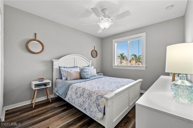 bedroom featuring ceiling fan, dark wood-style flooring, and baseboards