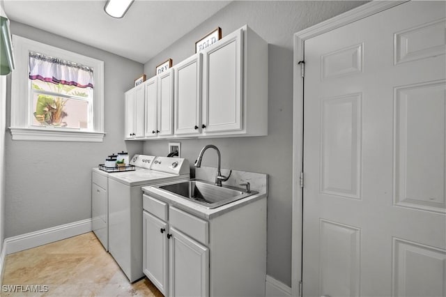 laundry room with baseboards, washing machine and clothes dryer, a sink, and cabinet space