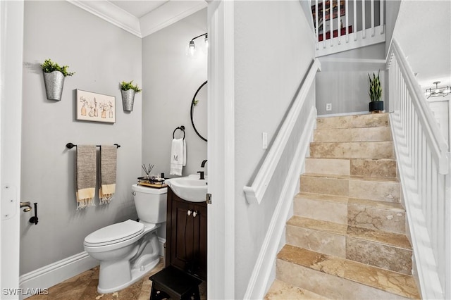 interior space featuring vanity, baseboards, crown molding, and toilet