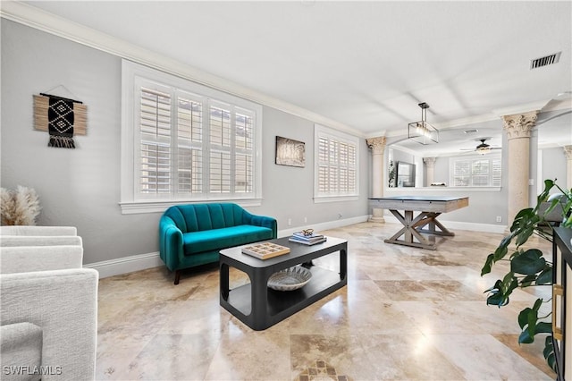 living room with decorative columns, baseboards, crown molding, and a ceiling fan