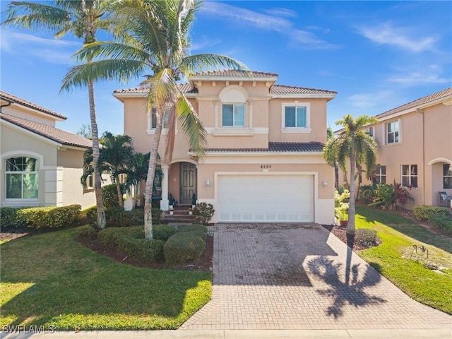 mediterranean / spanish house featuring a garage and a front lawn