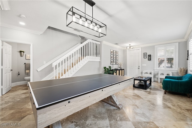 rec room featuring a healthy amount of sunlight, ornamental molding, and a notable chandelier