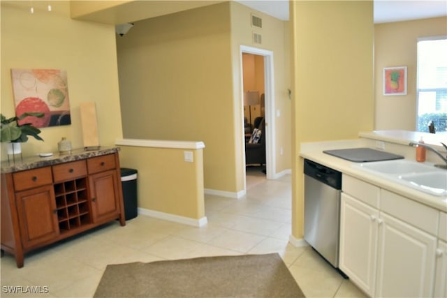 kitchen with dishwasher, sink, and light tile patterned floors