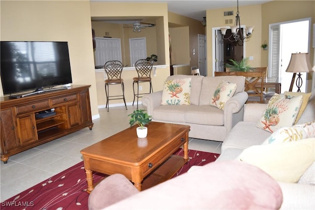 living room with ceiling fan with notable chandelier and light tile patterned floors