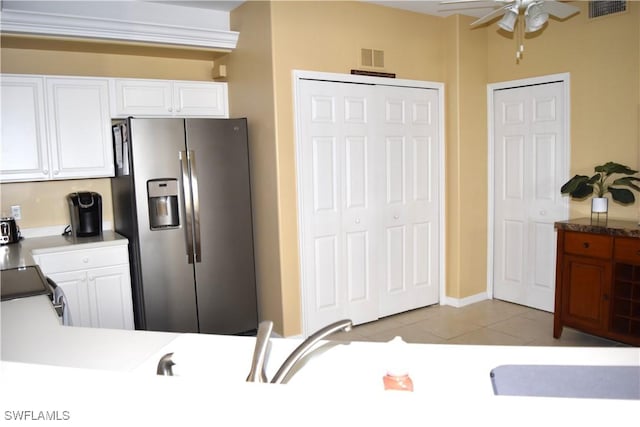 kitchen with stainless steel fridge with ice dispenser, ceiling fan, white cabinets, and light tile patterned flooring