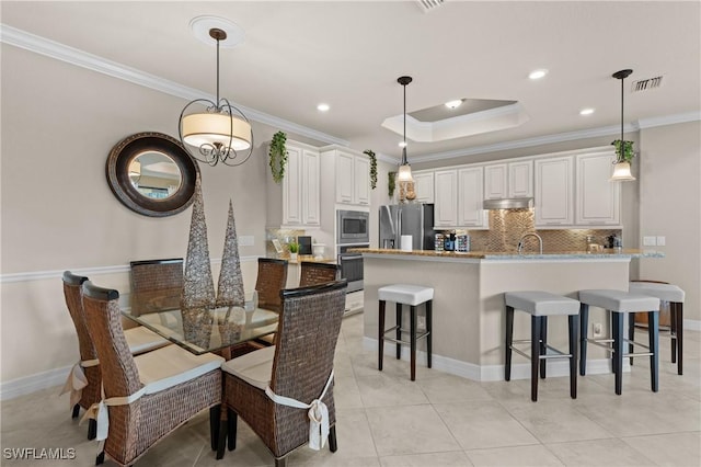 dining area with ornamental molding, visible vents, and baseboards