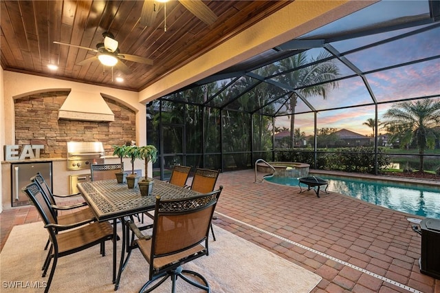 view of patio featuring an outdoor kitchen, glass enclosure, ceiling fan, grilling area, and a pool with connected hot tub