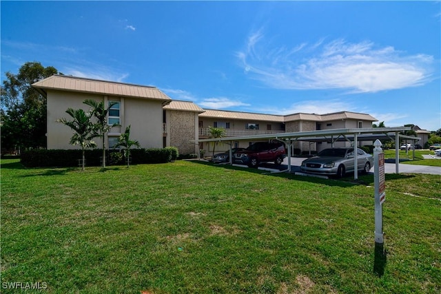 view of front of home with a carport and a front yard