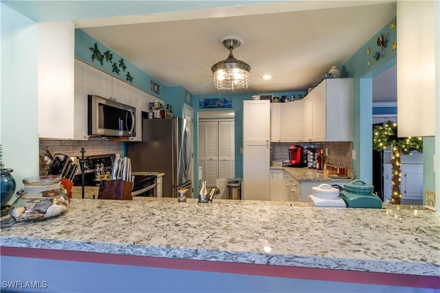 kitchen with white cabinetry, tasteful backsplash, and stainless steel appliances