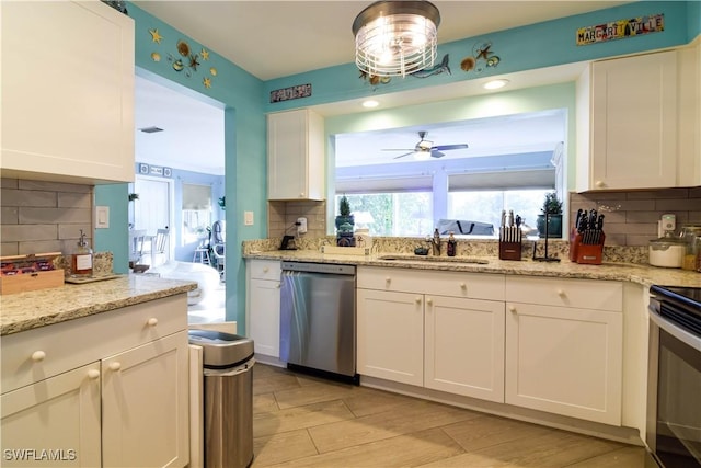 kitchen featuring sink, white cabinetry, stainless steel appliances, light stone counters, and tasteful backsplash