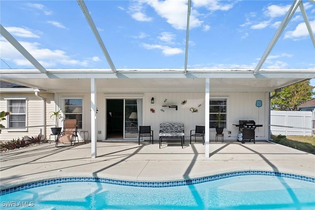 rear view of property with a patio, a fenced in pool, and glass enclosure