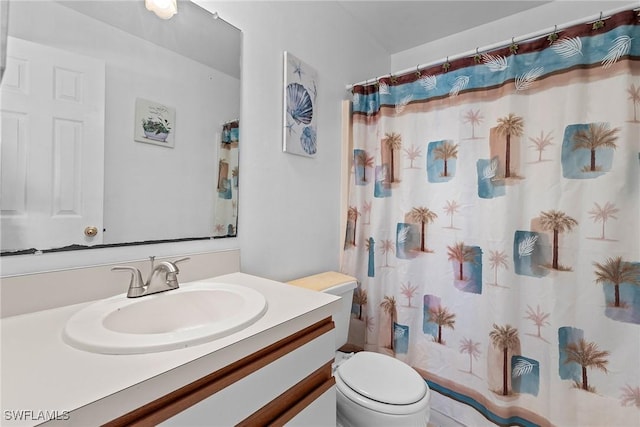 bathroom with vanity, a shower with shower curtain, and toilet