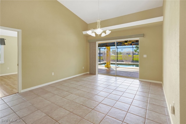 spare room featuring an inviting chandelier, light tile patterned floors, and high vaulted ceiling