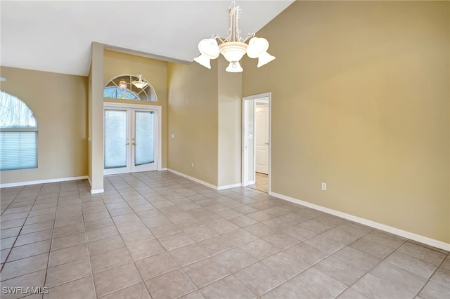 interior space with french doors, a healthy amount of sunlight, a chandelier, and high vaulted ceiling