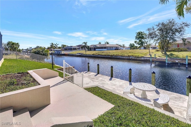 view of dock featuring a water view and a yard