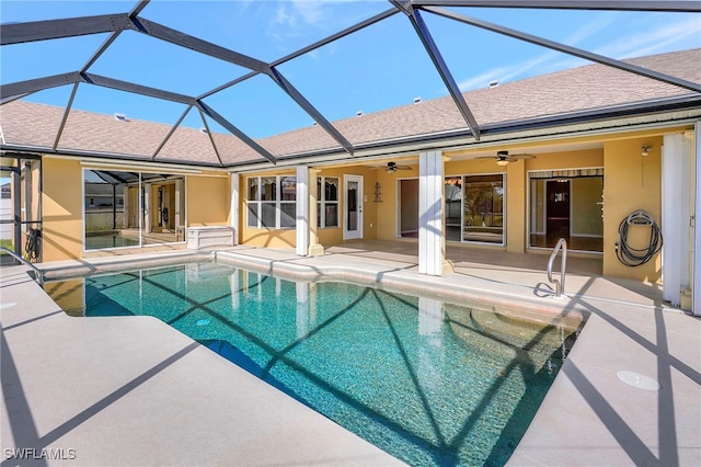 view of pool with a patio, ceiling fan, and glass enclosure