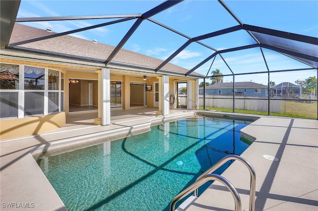 view of swimming pool featuring ceiling fan, a patio area, and glass enclosure