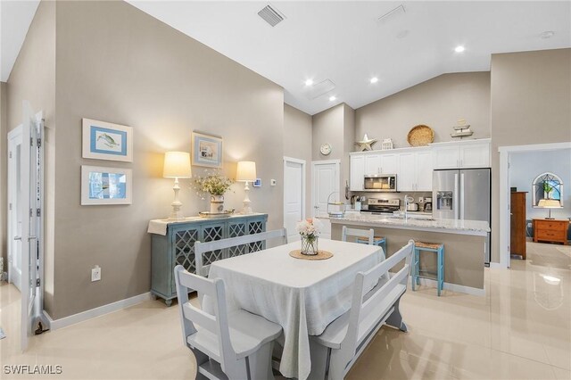 dining area with high vaulted ceiling