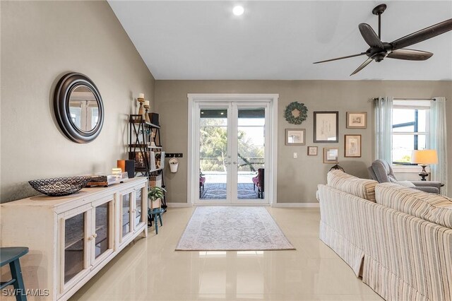 tiled entryway with lofted ceiling, ceiling fan, and french doors