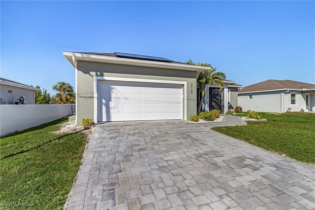 ranch-style house with a garage, a front lawn, and solar panels