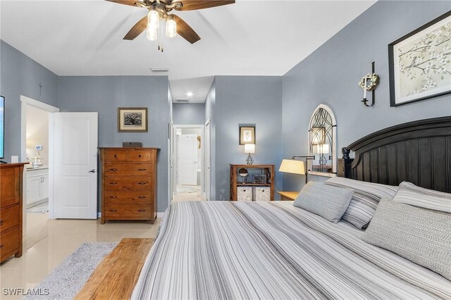 bedroom with light tile patterned flooring, ceiling fan, and connected bathroom