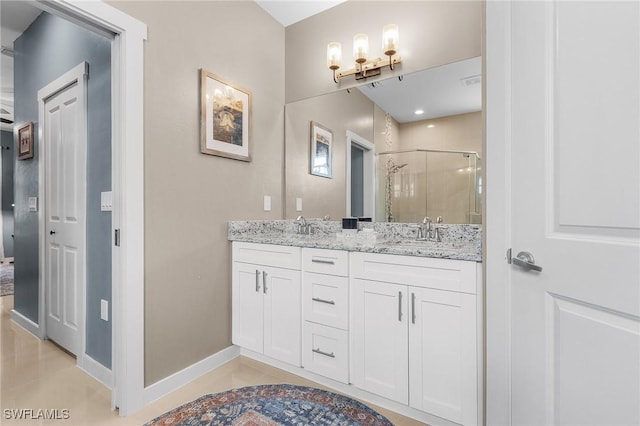 bathroom with an enclosed shower, vanity, and tile patterned flooring