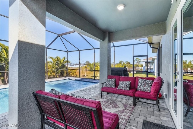 view of pool featuring an outdoor living space, a patio area, and glass enclosure