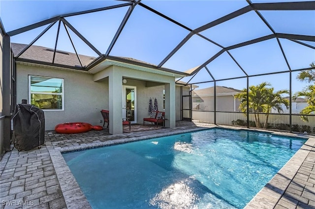 view of swimming pool with area for grilling, a patio area, and glass enclosure