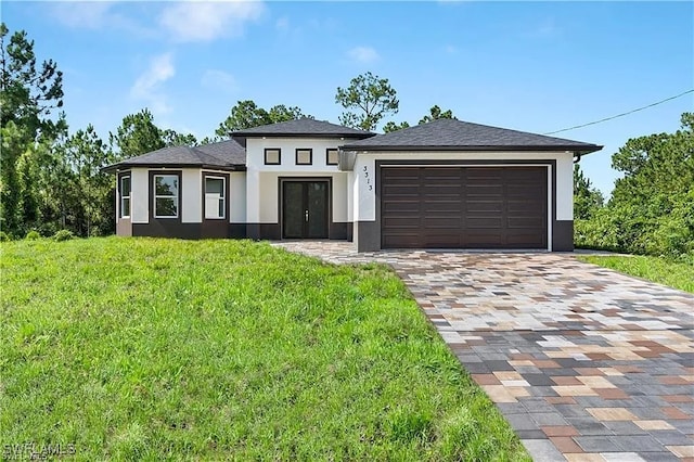 prairie-style home featuring a garage and a front lawn