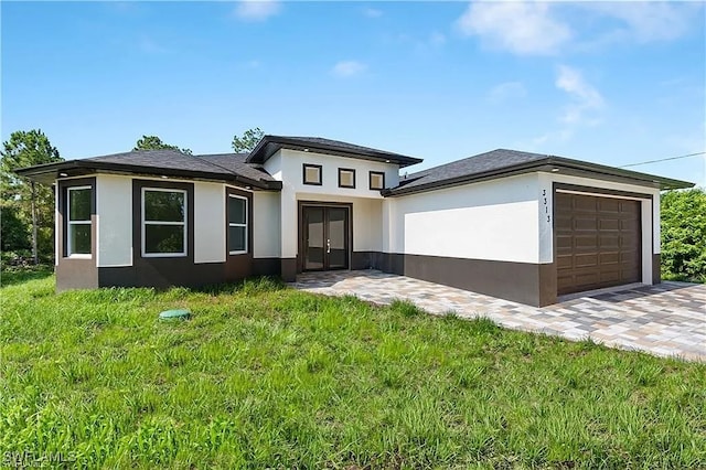 prairie-style home featuring a garage and a front lawn