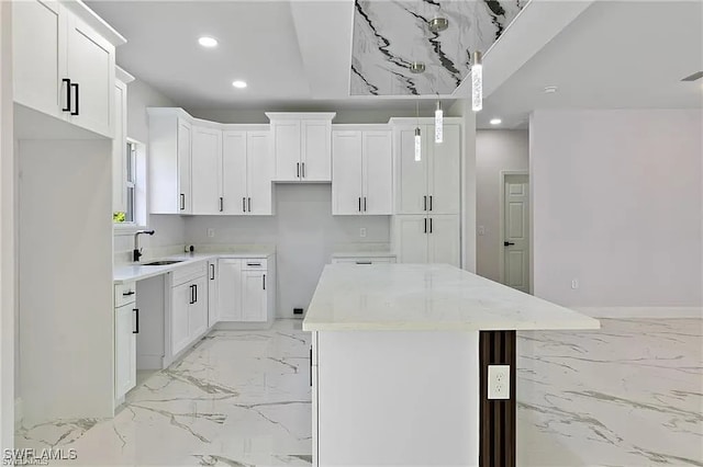 kitchen featuring light stone counters, white cabinets, and a kitchen island