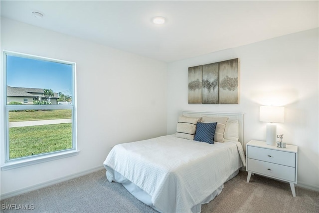 bedroom featuring light carpet and baseboards