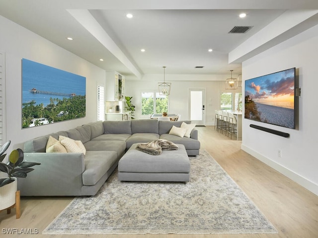 living area with light wood-style floors, recessed lighting, visible vents, and plenty of natural light