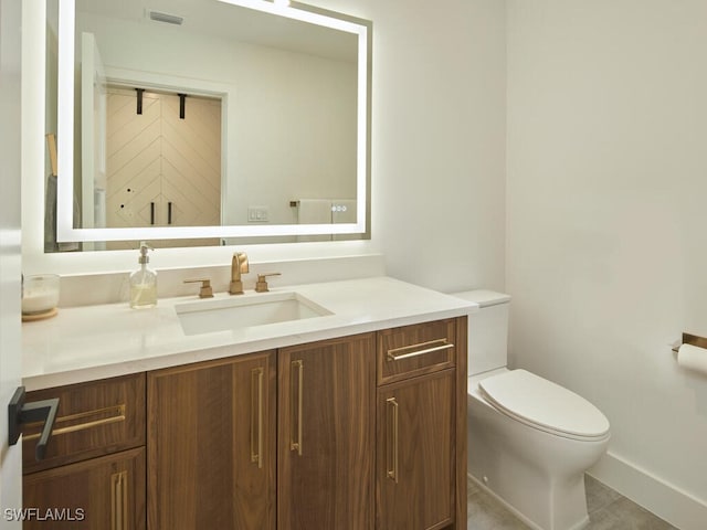 bathroom featuring toilet, vanity, and visible vents