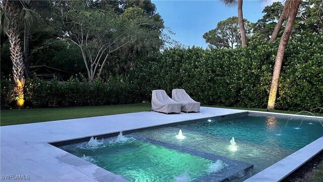 view of swimming pool featuring a patio, pool water feature, and a lawn