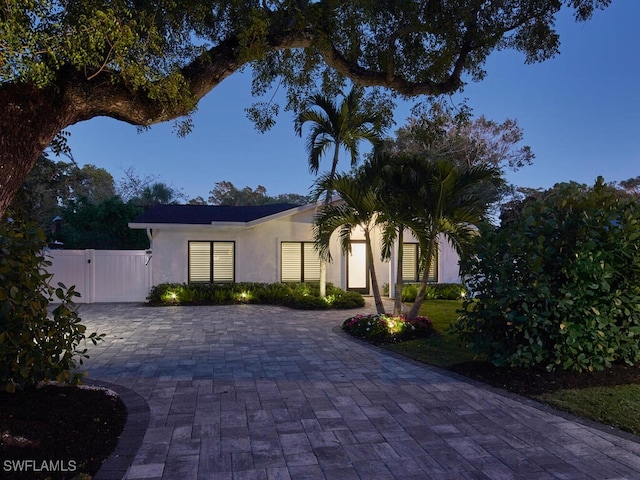 view of front facade with fence, a gate, and stucco siding