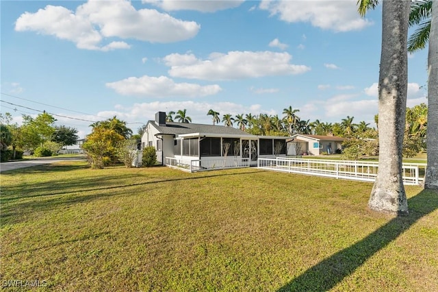 view of front of home with a front yard and a sunroom