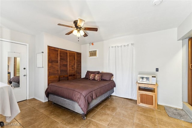 tiled bedroom featuring a wall mounted air conditioner, ceiling fan, and a closet