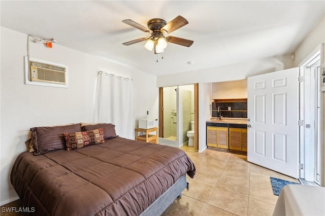 tiled bedroom featuring an AC wall unit, ceiling fan, and ensuite bathroom