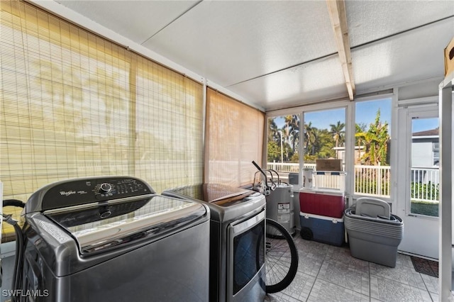 clothes washing area featuring gas water heater and washer and clothes dryer