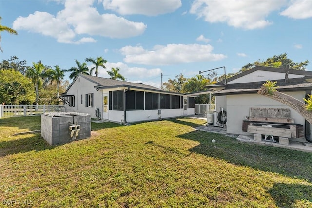 back of property with a sunroom and a lawn