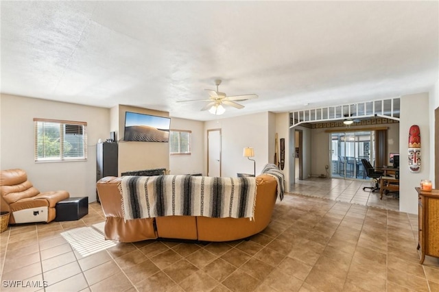 tiled living room with ceiling fan