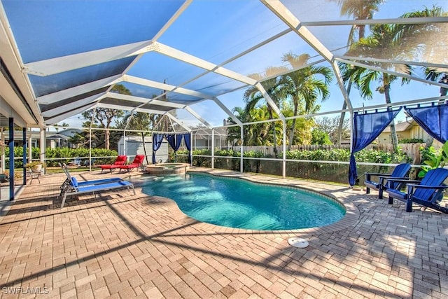 view of swimming pool featuring a storage shed, an in ground hot tub, a lanai, and a patio