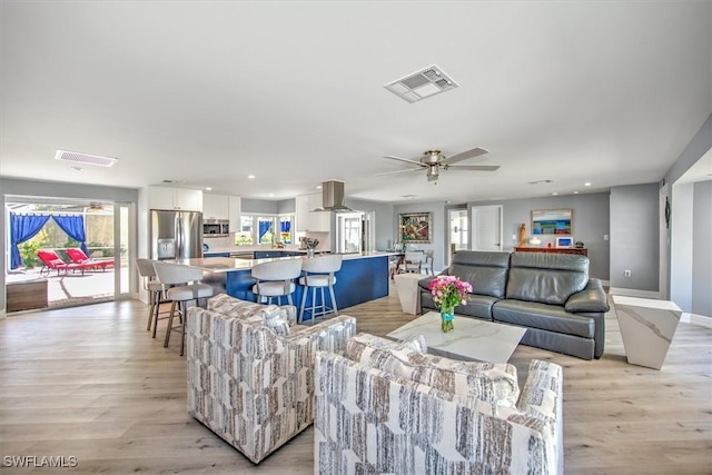 living room featuring ceiling fan and light wood-type flooring